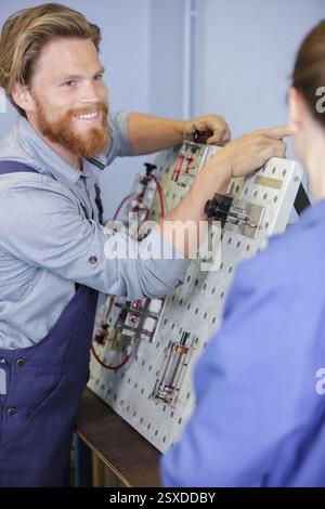 Mann und Frau bei einer padegogischen Elektrotafel Stockfoto