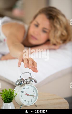 Nahaufnahme der weiblichen Hand, die den Wecker ausschaltet Stockfoto