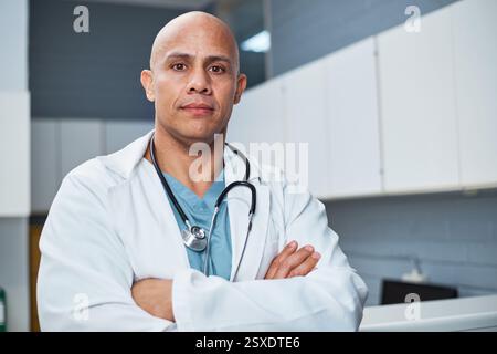 Erfahrener männlicher Arzt posiert selbstbewusst in einer Klinik, die Führung und medizinische Professionalität darstellt Stockfoto