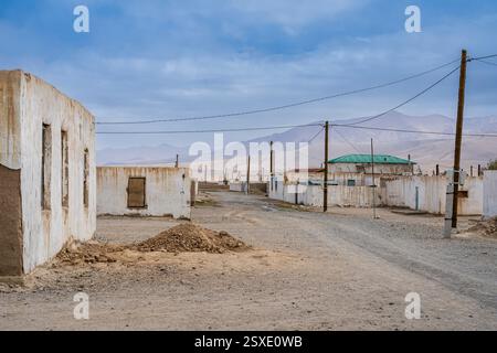 Landschaftsansicht der Straße mit weißen Häusern im hoch gelegenen Dorf Alichur entlang der Pamir Autobahn, Murghab, Gorno-Badakhshan, Tadschikistan Stockfoto