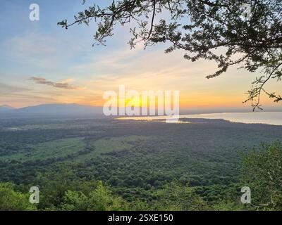 Ein atemberaubend schöner Sonnenuntergang über einer malerischen Landschaft mit einem See und majestätischen Bergen Lake Manyara Tansania Afrika Stockfoto