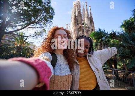 Zwei glückliche Touristen machen ein Selfie mit sagrada familia im Hintergrund an einem sonnigen Tag. Stockfoto