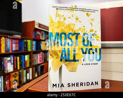 Lviv, Ukraine - 20. Februar 2025: "Most of All You" von Mia Sheridan, ein romantisches Buch in der Nähe von Bücherregalen. Stockfoto