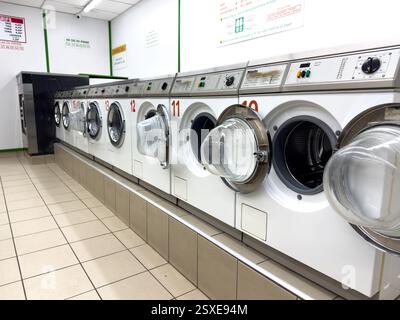 Heller Wäscheraum mit Maschinen, die an einem sonnigen Tag auf Service warten Stockfoto