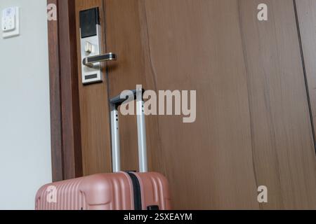 Ein Koffer befindet sich vor dem Hotelzimmer. Stockfoto