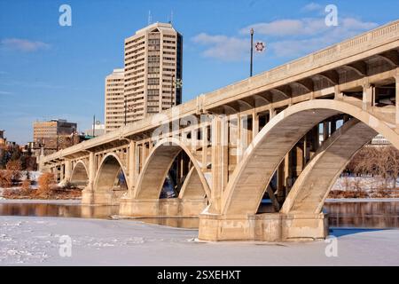 Bridge over a river with a city in the background. The bridge is made of concrete and has a large arch Stockfoto