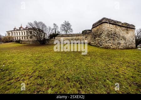 Eine große Steinmauer und ein historisches Gebäude sind auf dem deutschen Land zu sehen. Die Mauer ist Teil einer Festung und Stadtbefestigung von Forchheim, Bayern Stockfoto