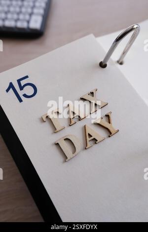 Nahaufnahme eines Kalenders mit dem 15. April mit Holzbuchstaben mit der Schreibweise „STEUERTAG“ Stockfoto