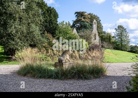 Wildschweinskulptur und Gräser in der Kieseinfahrt von Bayfield Hall, einem Landhaus aus dem 18. Jahrhundert in Norfolk, Großbritannien Stockfoto