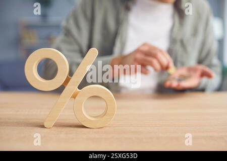 Nahaufnahme von Prozentsymbol und Mann, der Geld in seinen Händen zählt. Stockfoto
