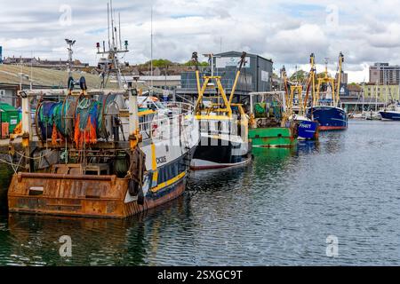 Farbenfrohe Fischerboote liegen am Fish Market Quay in Sutton Harbour, Plymouth, Devon, England. Stockfoto