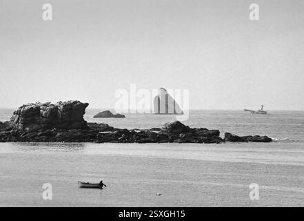 - Bretagne (Frankreich), Sommer 1978, am Horizont der Bug und die Überreste des Öltankschiffs Amoco Cadiz, der vor der bretonischen Küste sank und einen sehr schweren ökologischen Unfall verursacht hatte, weil Öl ins Meer und an die Küste gelangt ist. - Bretagna (Francia), Anwesen 1978, all'orizzonte la prua Ed i resti della petroliera Amoco Cadiz, affondata al largo delle coste Bretoni causando un gravissimo incidente ecologico per la fuoriuscita di petrolio nel Mare e sulla costa. Stockfoto