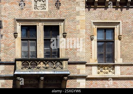 Zwei rechteckige Fenster mit Balkon und Basrelief in einem alten Backsteingebäude in Prag. Aus der Serie Windows of the World. Stockfoto