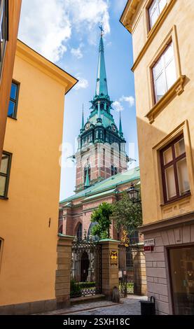 Glockenturm der deutschen Kirche in Gamla stan, der Altstadt von Stockholm, Schweden, von den engen Kopfsteinpflasterstraßen zwischen alten Gebäuden aus gesehen. Stockfoto