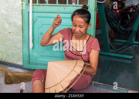Eine Frau, die traditionelle Handwerkskunst für die Herstellung von konischen Bambushüten in einem Haus auf Cu Lao Gieng oder Mango Island in Vietnam verrichtet hat. Stockfoto