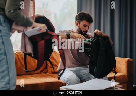 Studenten organisieren Rucksäcke auf einem Sofa für die Lerneinheit Stockfoto