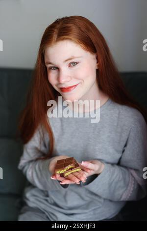 Mädchen halten in einer Hand Dubai Schokolade mit Pistazienpaste und Kataifi Teig in Händen von Mädchen. Stockfoto