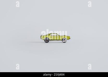 Ein grünes Spielzeugauto im klassischen Muscle Car-Design, das an einen Plymouth Barracuda aus dem Jahr 1970 erinnert. Isoliert auf weiß für einfache Verwendung. Stockfoto
