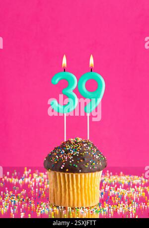 Geburtstagskuchen mit der Zahl 39 Kerze - Geburtstagskarte auf Fuchsia Hintergrund. Stockfoto