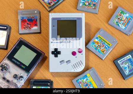 Fukuoka, Japan - 30. dezember 2024 : nintendo Game Boy and Game Boy Color mit verschiedenen Hit Game Patronen isoliert auf hölzernem Hintergrund Stockfoto