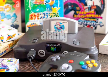 Fukuoka, Japan - 2. januar 2025 : nintendo N64 und verschiedene Hit-Spielkassetten auf einem Holztisch Stockfoto