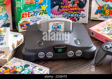 Fukuoka, Japan - 2. januar 2025 : nintendo N64 und verschiedene Hit-Spielkassetten auf einem Holztisch Stockfoto