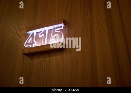 Das Zimmer des Glowing Hotels ist an der Holztür angebracht Stockfoto