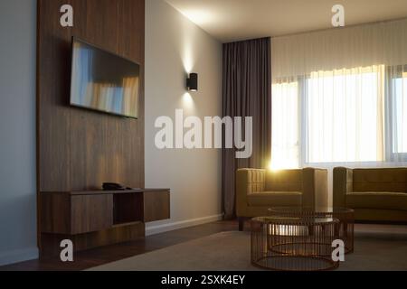 Gemütliches Wohnzimmer mit modernem Fernseher an der Wand Stockfoto