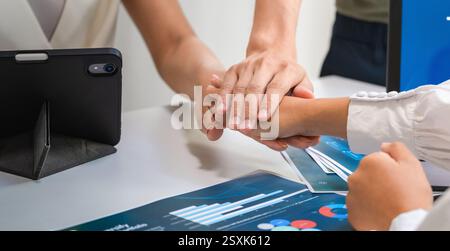 Das Nahteam zeigt Einheit und Unterstützung, indem es die Hände in einem Geschäftssitzungsbüro zusammenlegt Stockfoto