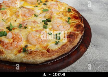 Vier Käse-Pizza mit Garnelen und frischem Mikrogrün, serviert auf Holzbrett, hausgemacht, keine Leute Stockfoto
