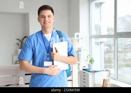 Männlicher Arzt mit Laptop in der Klinik Stockfoto