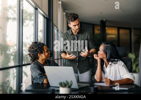 Geschäftskollegen, die während eines Meetings in einem modernen Büro ein Missverständnis haben und streiten Stockfoto