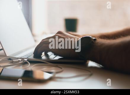 Hände des jungen modernen Büroleiters über Laptop-Tastatur Stockfoto