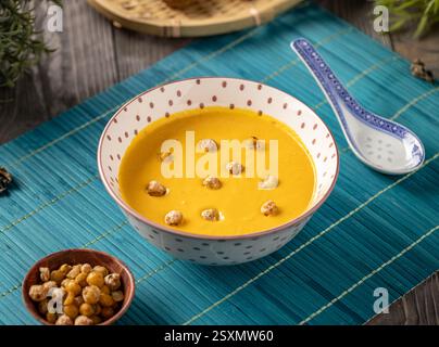 Cremige Kürbissuppe garniert mit gerösteten Kichererbsen in einer Schüssel Stockfoto