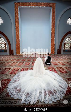 Islamische Hochzeitszeremonie in der Moschee. Braut und Bräutigam sitzen in einer Moschee bei einer muslimischen Hochzeitszeremonie. Stockfoto