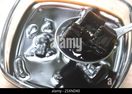 Schwarzes Grasgelee chinesisches kaltes Süßfleisch in Sirup in einer Glasschale Stockfoto