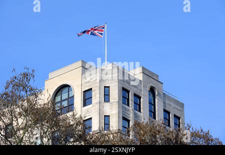 London, Großbritannien. Union Flag, die vom Dach des Adelphi Building in The Strand aus gesehen wird, von Victoria Embankment Gardens aus gesehen Stockfoto