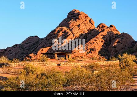 Großer, felsiger Berg mit einer Bank auf der Spitze. Die Bank befindet sich auf der Seite des Berges und bietet eine malerische Aussicht für diejenigen, die darauf sitzen. Der ben Stockfoto