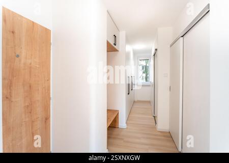 Moderner und minimalistischer Flur mit weißen Wänden und Holzfußboden Stockfoto