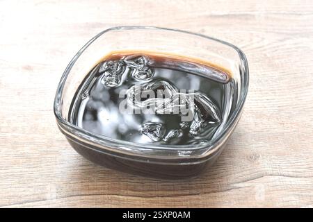 Schwarzes Grasgelee chinesisches kaltes Süßfleisch in Sirup in einer Glasschale Stockfoto