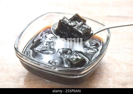 Schwarzes Grasgelee chinesisches kaltes Süßfleisch in Sirup in einer Glasschale Stockfoto