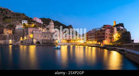 Abendlicher Panoramablick auf das Fischerdorf Vernazza mit bunten Häusern und Sonnenuntergang. Nationalpark Cinque Terre, Ligurien, Italien. Landschaftsfotografie Stockfoto