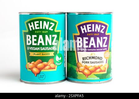 London, Großbritannien 25. Februar 2025 :- Dosen von Heinz Baked Beans mit Schweinefleisch und veganen Würstchen. Studio vor weißem Hintergrund Stockfoto