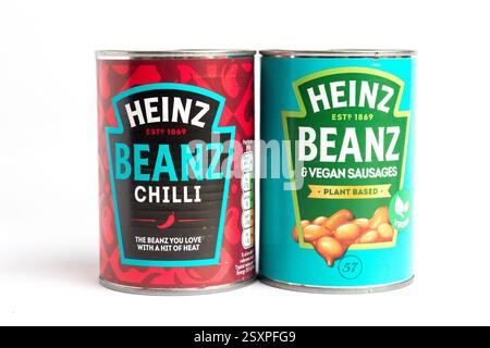 London, Großbritannien 25. Februar 2025 :- Dosen von Heinz Baked Beans mit veganen Würstchen und Chilli. Studio vor weißem Hintergrund Stockfoto