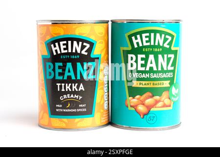 London, Großbritannien 25. Februar 2025 :- Dosen von Heinz Baked Beans mit veganen Würstchen und Tikka. Studio vor weißem Hintergrund Stockfoto
