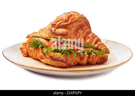 Dieses leckere Croissant-Sandwich ist gefüllt mit frischem Salat, Reifen Tomaten und knusprigen Gurken auf einem Teller Stockfoto