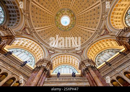 WASHINGTON DC – der Hauptlesungsraum der Library of Congress Thomas Jefferson Building verfügt über eine prächtige Kuppeldecke mit Edwin Blashfields allegorischen Gemälden, die Länder darstellen, die zur westlichen Zivilisation beigetragen haben. Acht riesige Marmorsäulen tragen 10 Fuß hohe Gipsfiguren, die Religion, Handel, Geschichte, Kunst, Philosophie, Poesie, Recht und Wissenschaft. Der zentrale Leseraum darunter enthält in konzentrischen Kreisen angeordnete Forscherpulte unter dem 1897 fertiggestellten architektonischen Meisterwerk. Stockfoto