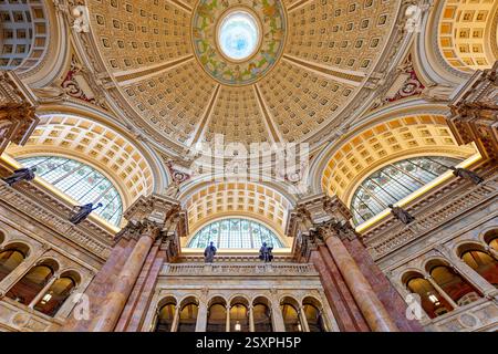 WASHINGTON DC – der Hauptlesungsraum der Library of Congress Thomas Jefferson Building verfügt über eine prächtige Kuppeldecke mit Edwin Blashfields allegorischen Gemälden, die Länder darstellen, die zur westlichen Zivilisation beigetragen haben. Acht riesige Marmorsäulen tragen 10 Fuß hohe Gipsfiguren, die Religion, Handel, Geschichte, Kunst, Philosophie, Poesie, Recht und Wissenschaft. Der zentrale Leseraum darunter enthält in konzentrischen Kreisen angeordnete Forscherpulte unter dem 1897 fertiggestellten architektonischen Meisterwerk. Stockfoto