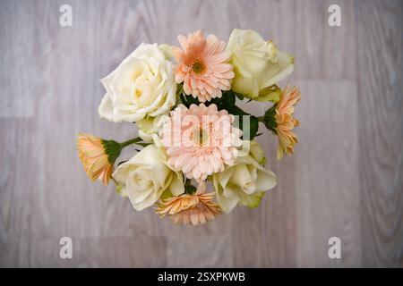 Blumenstrauß aus bunten Gerbera-Blumen und weißen Rosen auf einem hölzernen Hintergrund mit negativem Raum Stockfoto