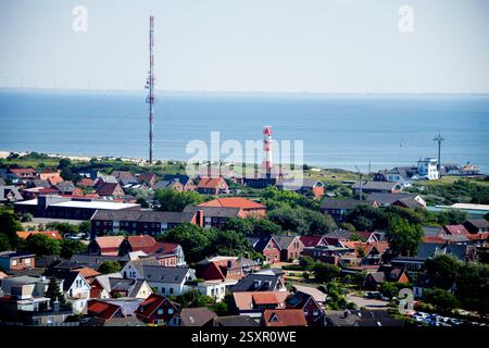 Borkum, Deutschland. Juni 2024. Zahlreiche Häuser sowie der elektrische Leuchtturm und der Küstenradiosender (links) befinden sich im Ortskern der Nordseeinsel Borkum, fotografiert vom Neuen Leuchtturm. Quelle: Hauke-Christian Dittrich/dpa/Alamy Live News Stockfoto